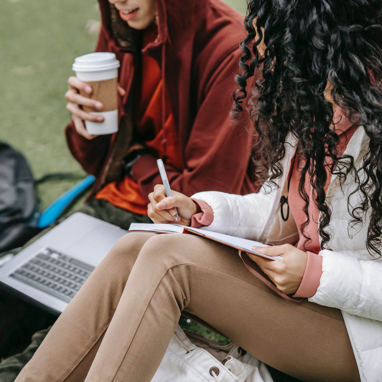 crop students studying together on grassy lawn