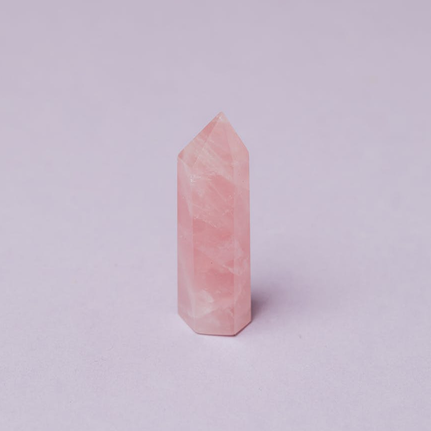 light pink crystal of rose quart against gray background in studio