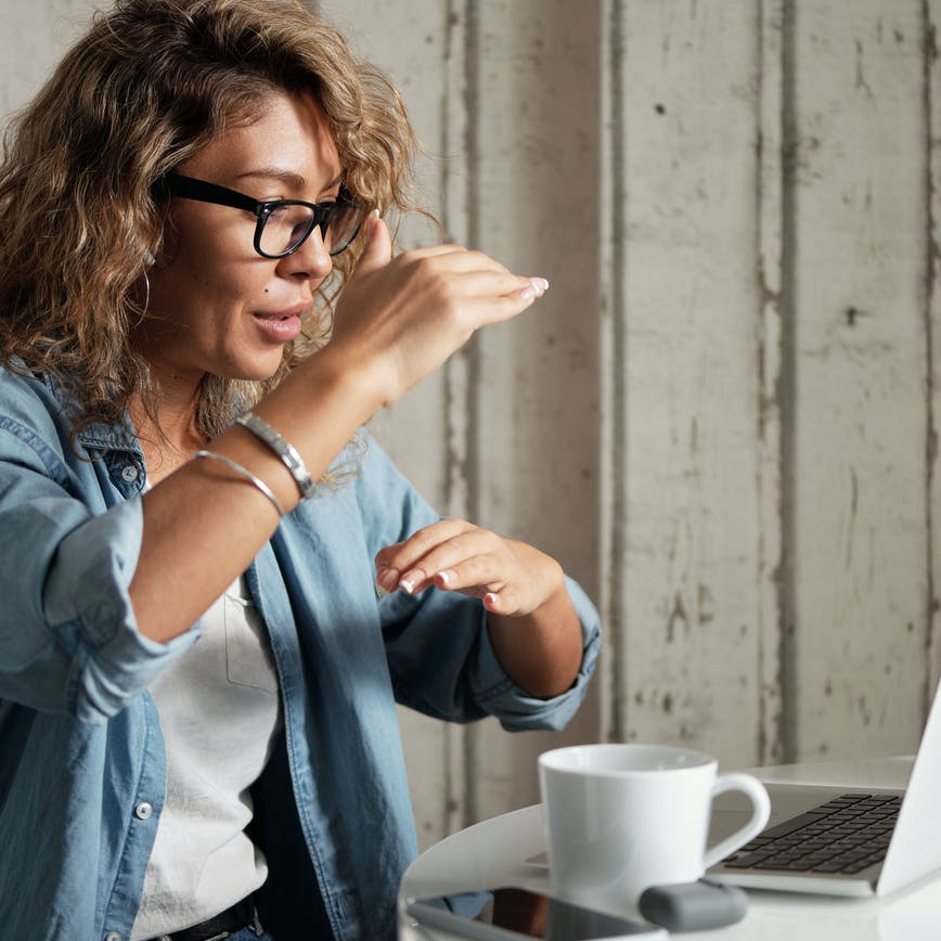 woman in blue denim jacket using a laptop