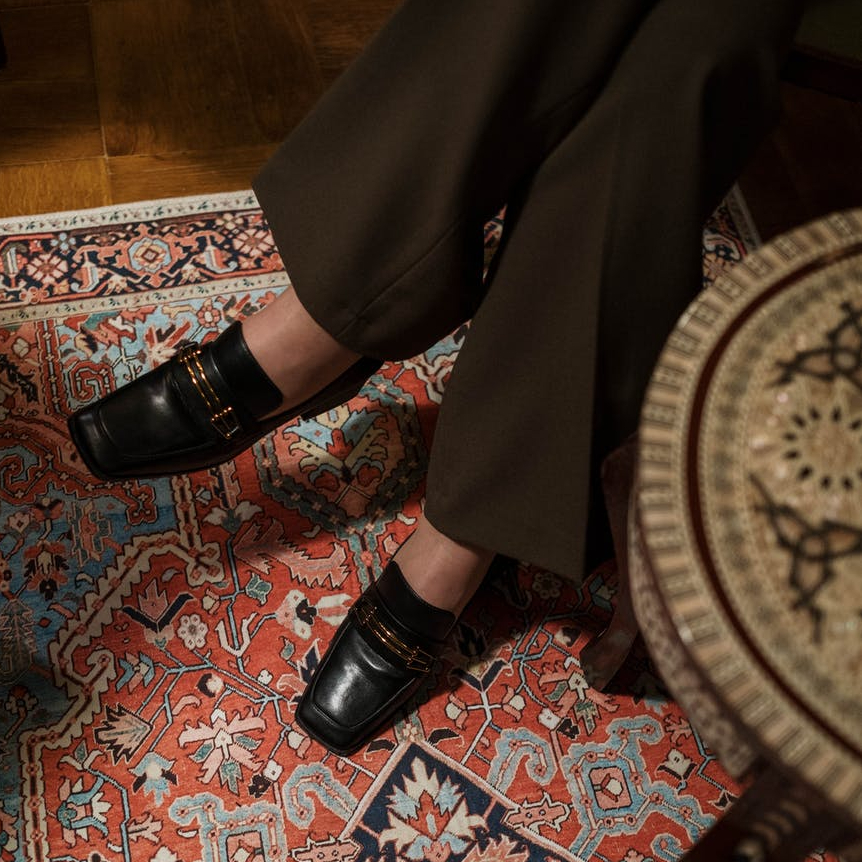 person wearing black leather shoes